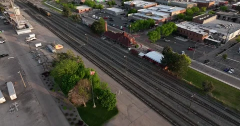 Pull back flight viewing small town depot tracks with some traffic under tracks Stock Footage 335670157