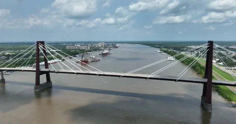Pull back flight viewing the suspension bridge and ships and barges on the river Stock Footage 335671741