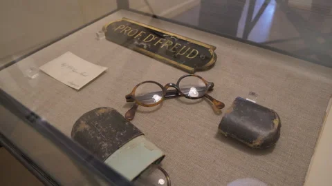 Pull back from glasses and nameplate in display case of Sigmund Freud Museum Stock-Footage 285104826
