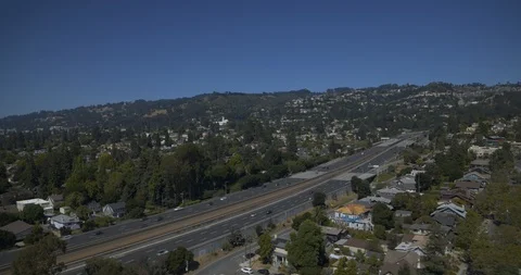 Pull back of highway through city hills 库存影片 117323052