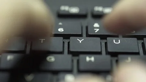 Pull back reveal of man typing on a computer keyboard 4k Stock Footage 72256377