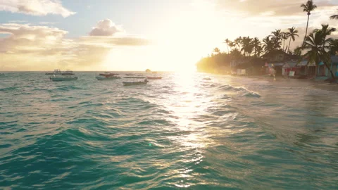 A pull back reveal over turquoise waves washing a resort beach in Punta Cana Stock Footage 316245689
