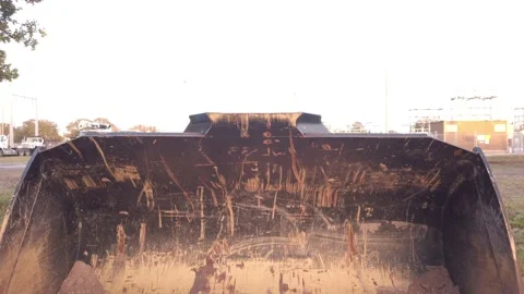 Pull back shot Front view of yellow scraped marked wheel loader, scraper and gra Stock Footage 263904031