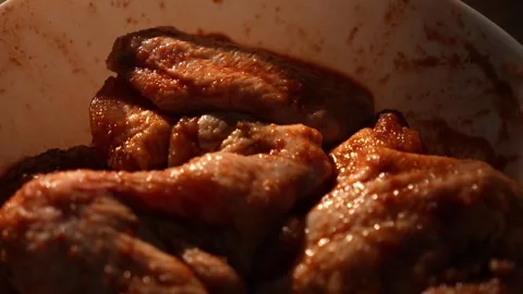 Pull back shot of marinated chicken wings in white bowl Stock Footage 312647989