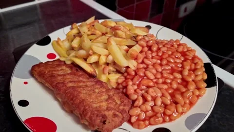 Pull back shot of oven baked fish fillet, oven fries and baked beans on a plate Video stock 258072165