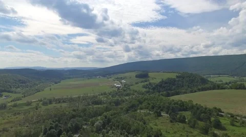 Pull back trees mountains sky aerial Stock Footage