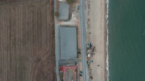 Pull back view of an asphalt road while car is driving through. 4K drone video Video stock 164880856