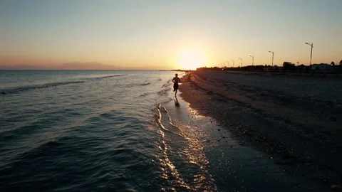 Pull back view of young boy running on the beach. Stock Footage 161084358