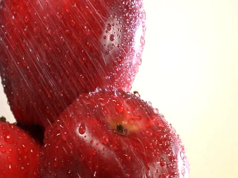Pull back from water showering on stack of rotating red apples Stock Footage 46585189