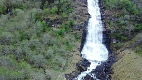 Pull back from waterfall in Norwegian landscape with mountains and forest Stock Footage 314842382