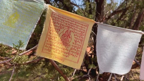 Pull back from a yellow Buddhist prayer flag to reveal a string of Stock Footage 157090145