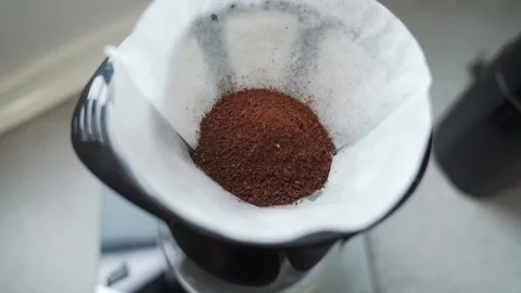 Pull bakc shot of ground coffee beans in a coffee filter Stock Footage 92263376