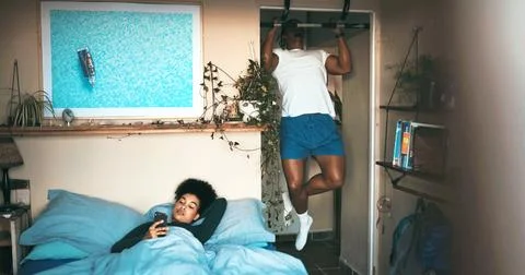 Pull up bar, couple or phone in bedroom, home workout routine or check soci.. Stock Photos