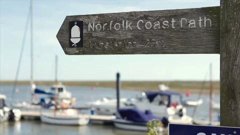 Pull focus from boats in the sea to Norfolk Coast Path signpost 스톡 동영상 76434703
