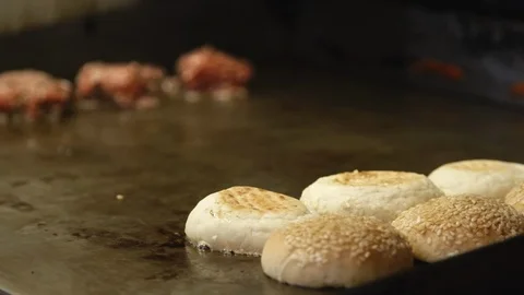 Pull focus from bread buns to meatballs cooking on hot plate Stock Footage 91371088