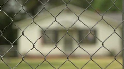 Pull Focus from Chainlink Fence to Residential Home HD Video Stock Footage 92801294