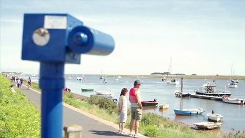 Pull focus from coin operated telescope to tourists on English seaside 스톡 동영상 76434456