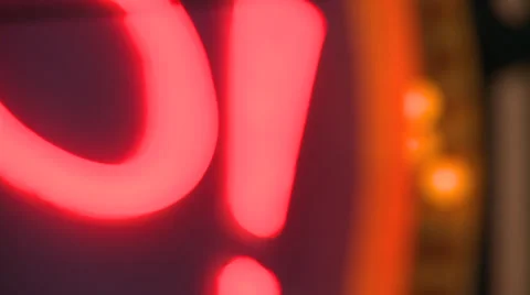 Pull focus CU on big red neon exclamation mark with flashing orange lights Stock Footage 39604179