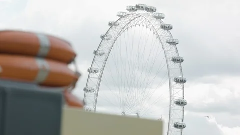 PULL FOCUS FROM LIFE PRESERVER ON FLOATING BOAT TO LONDON EYE Stock Footage 126509960