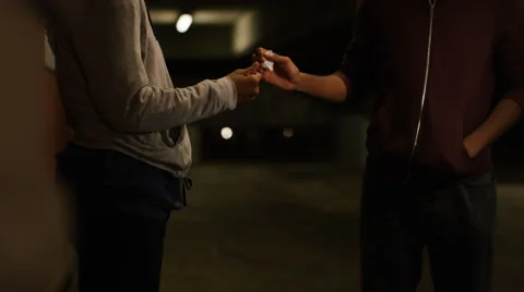 Pull focus from pipe to anonymous person buying drugs, in slow motion Video stock 66447437