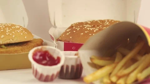 Pull focus shot of a fast food restaurant meal with fries, burger and sauce. Video stock 77726990