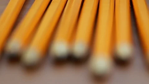 A pull focus shot of a row of pencils on the table - camera focus shifts from lo Stock Footage 88487893