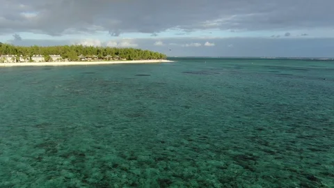Pull in opening shot camera moving forward over tropical lagoon at sunset time Stock Footage 120426650