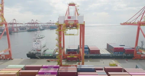 Pull Out Aerial Shot Of A Quayside Crane Moving Container from Cargo Ship Stock Footage 332668794