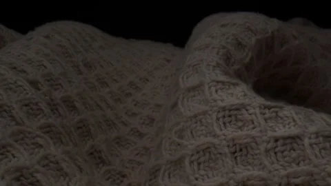 Pull-out close-up of thick knitted white blanket with dark background Stock Footage 242520829