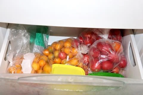 Pull-out freezer drawer with plastic bags with frozen vegetables red and ye.. Stock Photos