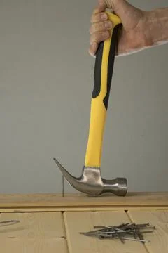 Pull out the nail with a claw hammer. The hammer is removing the nail from th Photos