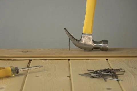 Pull out the nail with a claw hammer. The hammer is removing the nail from th 写真素材