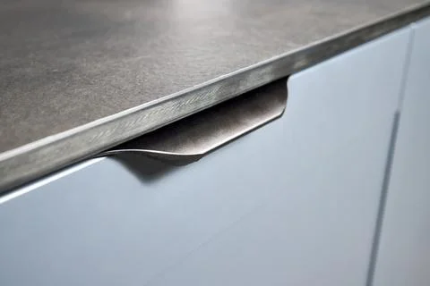 Pull out rack cabinet drawer handle closeup. Flush up slip handle finger pull Stock Photos