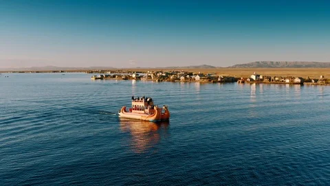 Pull-out from reed boat at Uros Floating Islands, Lake Titicaca at sunset Stock Footage 115369174