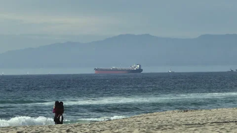 Pull Out From A Ship Offshore To A Couple Hugging On The Beach Stock Footage 238840049