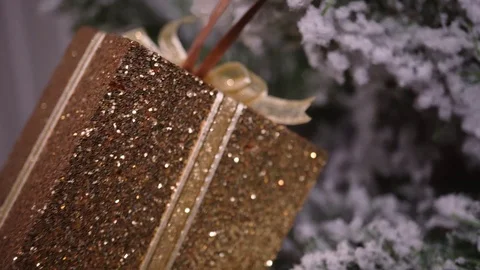 Pull out shot of golden glitter gift box Christmas ornament on Christmas tree Stock Footage 97782449