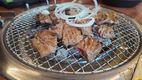 Pull Out Shot of Meat Cooking Over Charcoal Grill at Korean BBQ – 4K 60fps Video stock 329302795