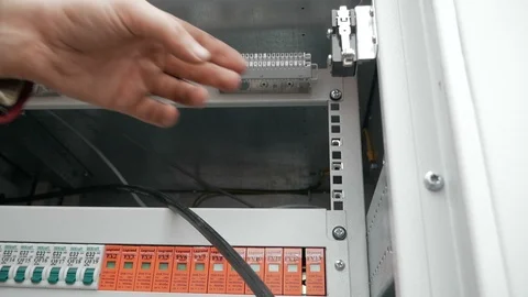 Pull-out shot of a optical fiber switchboard hub with a blurred technician Stock Footage 126950909