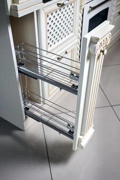 Pull out spice rack cabinet filler pantry. Interior of modern kitchen in clas Stock Photos