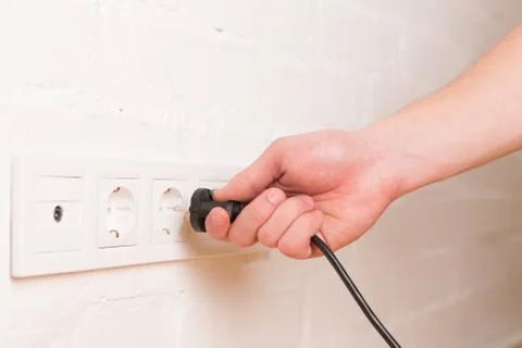 Pull the plug concept with man pulling black cord and plug Stock Photos