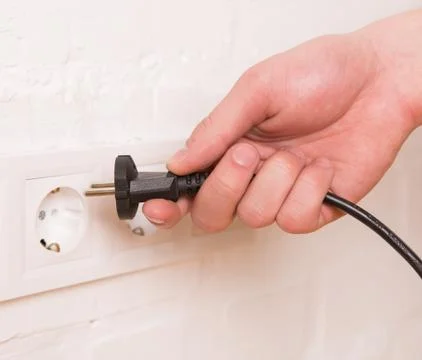 Pull the plug concept with man pulling black cord and plug Stock Photos