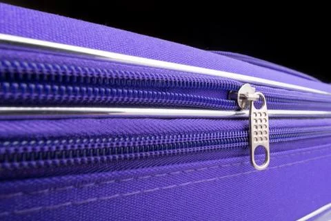 Pull Tab and Chain of a Zipper on a Violet Suitcase 写真素材