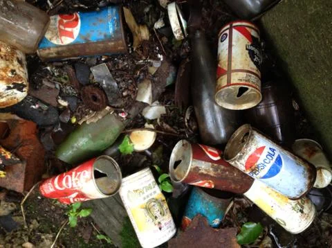 Pull-Top soda pop cans and beer cans in garbage trash pile, broken bottles Stockfoto's