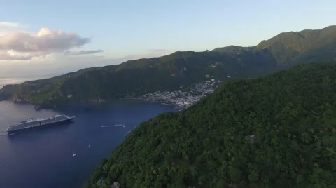 Pull in towards town in Mountain base. Cruise ship docked nearby Stock Footage 66340609