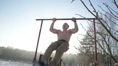 Pull ups with a naked torso outdoors in winter Video stock 147224398