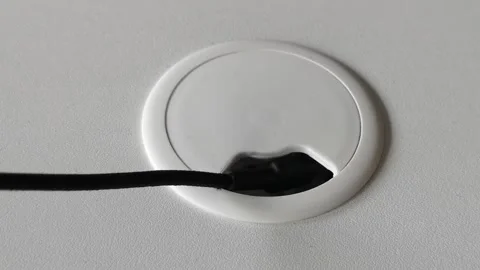 Pull the wire out of the hole for electric wire and cable on computer desk Stock Footage 280033425