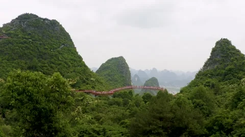 Pullback Aerial of Red Skybridge Between Yangshuo Karst Peaks Stock-Footage 329029176