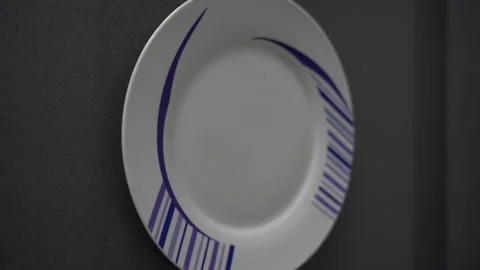 Pullback from clean white plate with blue linework pattern on grey Stock Footage 266914989