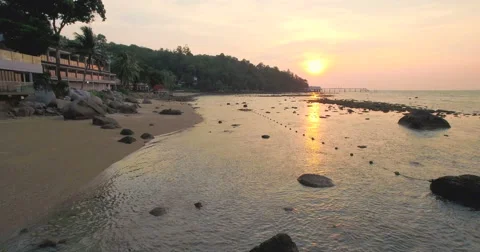 Pullback Drone Shot of Rocks And Beach Resort At Sunset 스톡 동영상 64122813