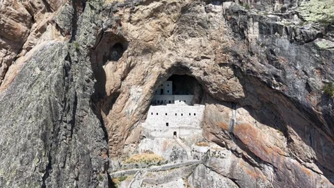 Pullback Revealing Ancient Cliffside Stone Structure in Mountain Landscape Stock Footage 339440480
